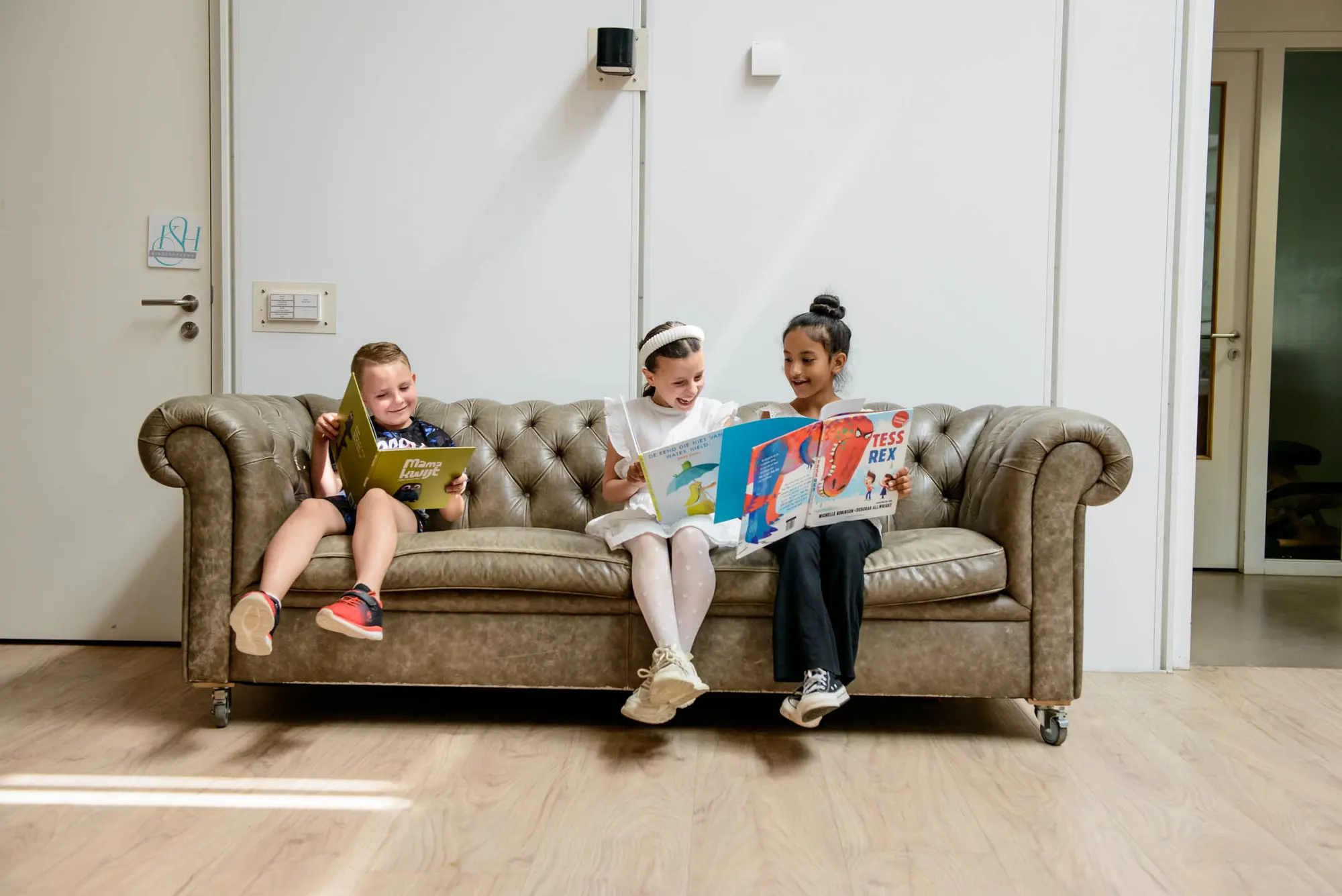 Kinderen lezen boek op bank